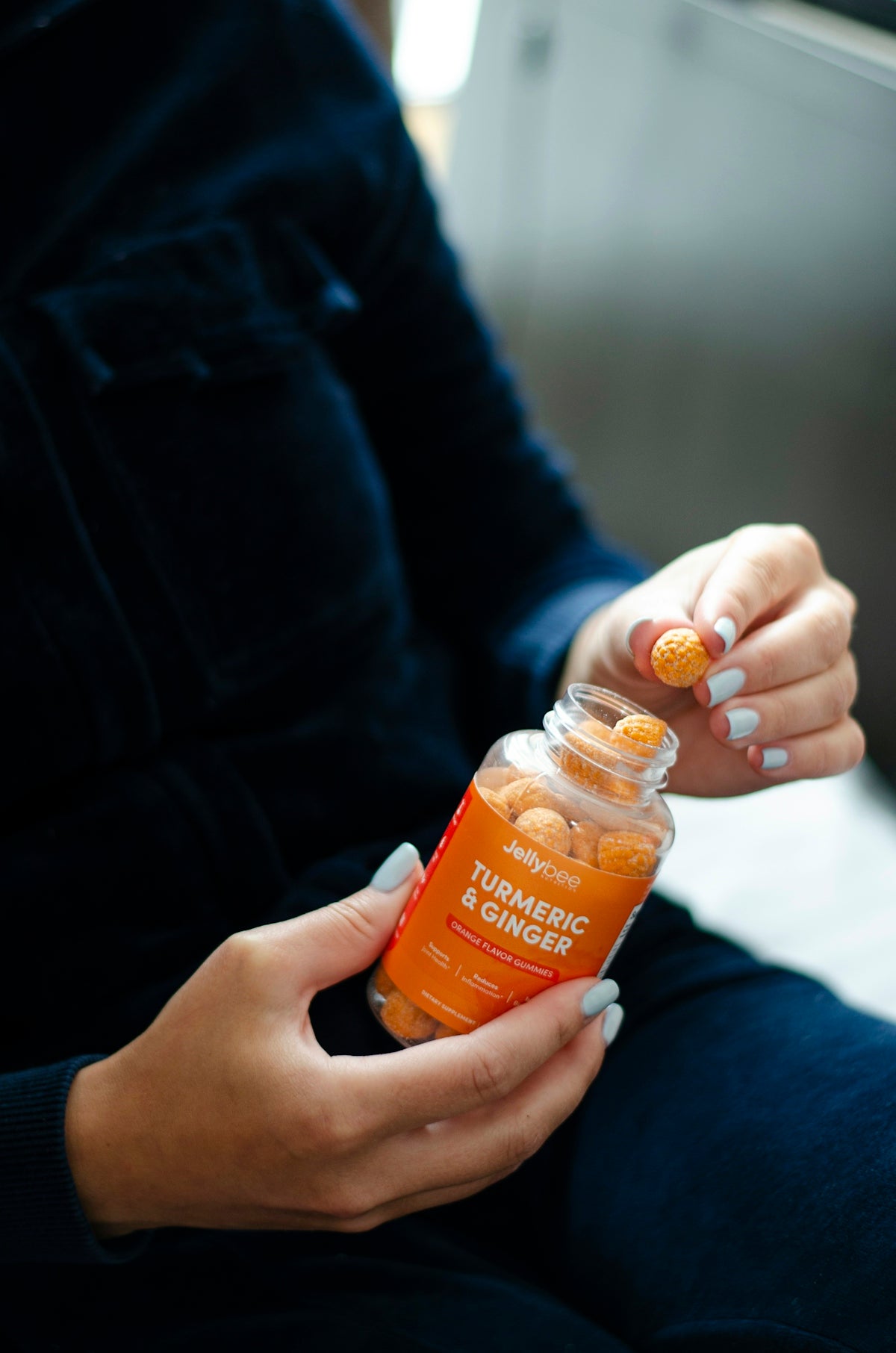 person holding orange plastic bottle