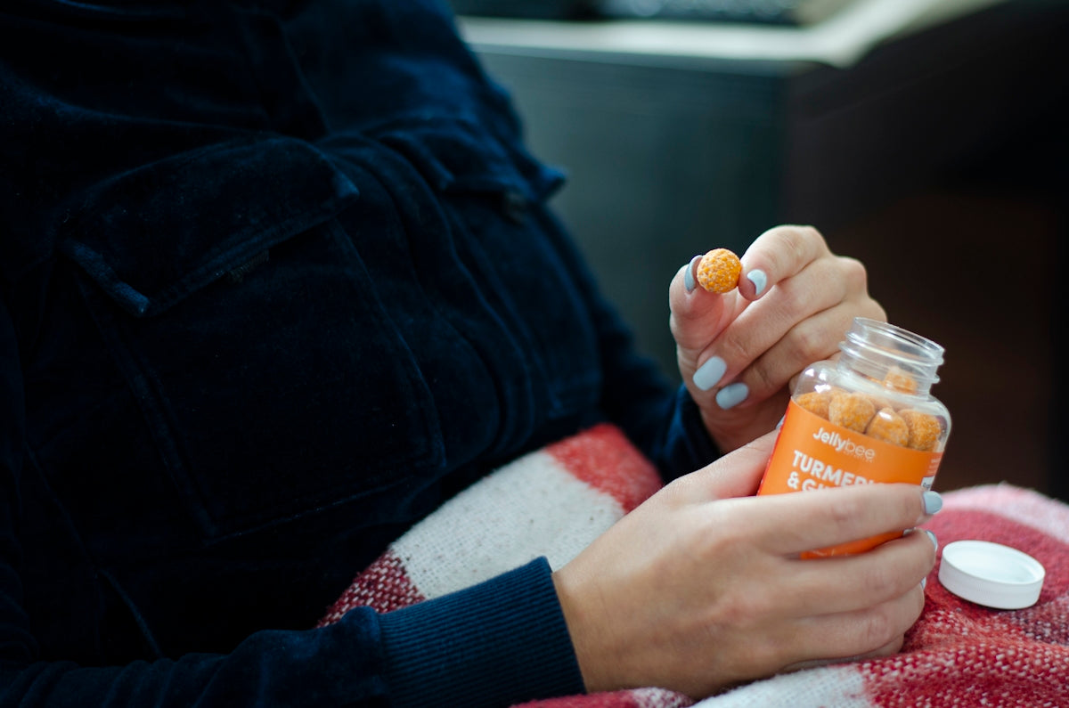 person holding orange plastic bottle