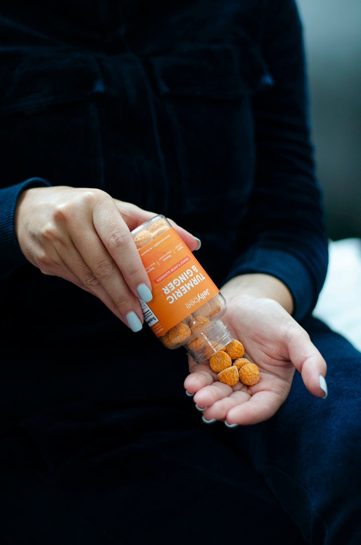 person holding orange plastic bottle