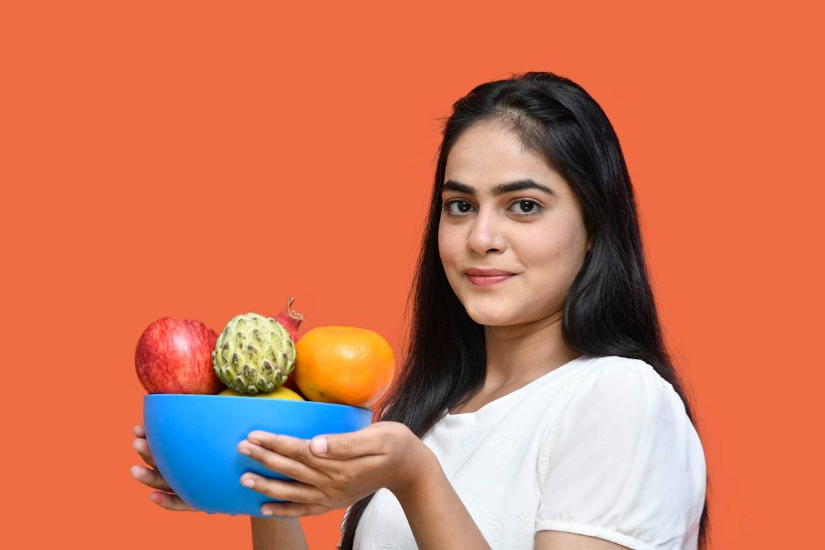 a person holding a bowl of fruit